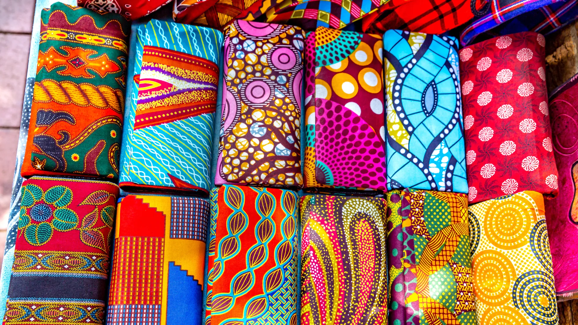 Folded African wax-print fabrics in a market stall
